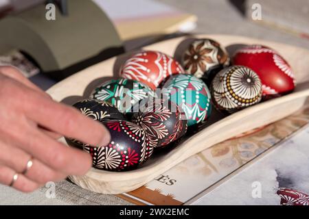 Traditional Lithuanian wooden colorful Easter eggs in a wicker basket, symbol of fertility and life painted with the symbols of nature Stock Photo