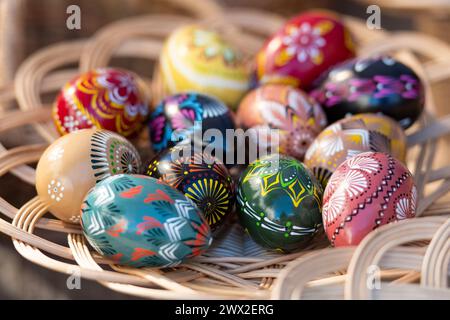 Traditional Lithuanian wooden colorful Easter eggs in a wicker basket, symbol of fertility and life painted with the symbols of nature Stock Photo