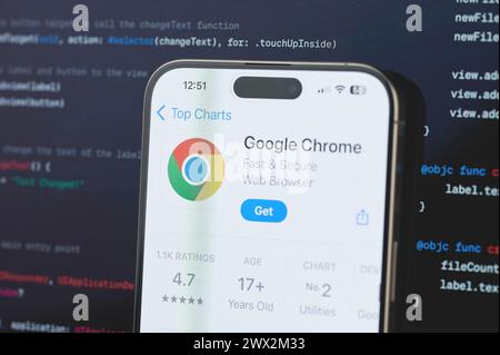 New York, USA - February 23, 2024: Google chrome  on iphone screen in blurred code programming background Stock Photo