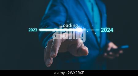 Businessman touch on loading progress from 2023 to 2024,Planning and challenge strategy in new year 2024 Concept. New business startup in 2024. New ye Stock Photo
