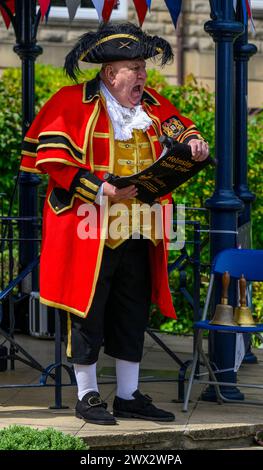 Male town crier (colourful crier's uniform, loud voice) proclaiming, making public proclamation & announcement - Ilkley, West Yorkshire, England, UK. Stock Photo