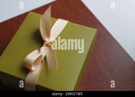 Gift box in a simple business style on a leather folder for papers Stock Photo