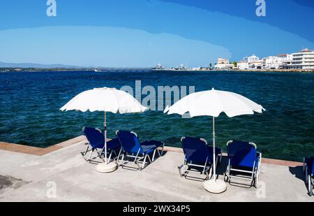 Amazing View on  Spetses - one of fantastic of Greek islands and   outdoors chairs and umbrellas of white and blue  color.Fantastic summer recreation Stock Photo