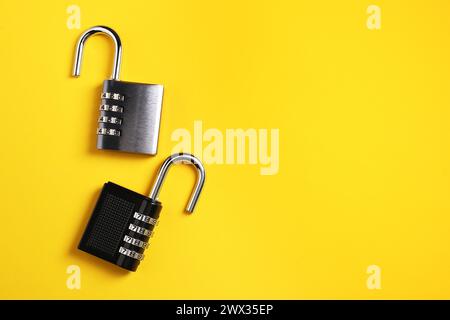 Steel combination padlocks on yellow background, top view. Space for text Stock Photo