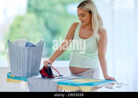 Pregnant woman ironing Stock Photo