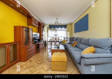 Conventional living room with long green fabric sofa and wooden sideboard bookcase Stock Photo