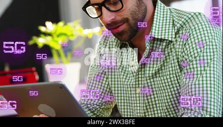 Image of multiple 5g texts over smiling caucasian man watching image on digital tablet at cafes. Digital composite, multiple exposure, business, bever Stock Photo