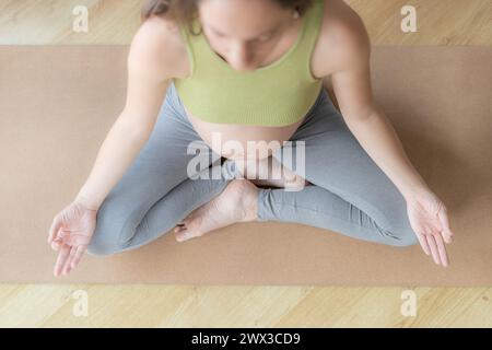 Pretty young pregnant woman performing meditation and yoga exercises Stock Photo