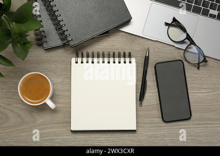 Flat lay composition with notebooks, laptop and smartphone on wooden table Stock Photo