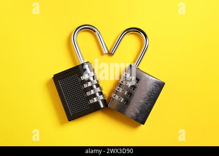 Steel combination padlocks on yellow background, top view Stock Photo