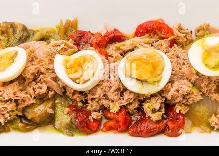 Traditional Spanish food. Roasted pepper salad with vegetables, tuna and hard-boiled eggs. top view. Stock Photo