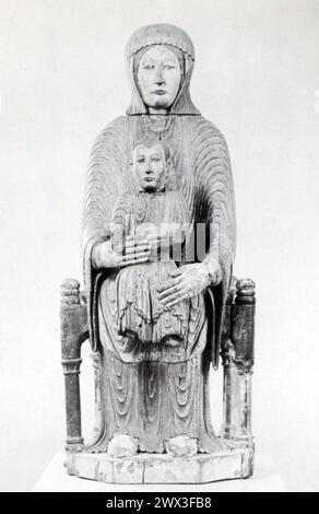 A painted wooden statue of the Virgin and Child, crafted from oak, originating from Auvergne, France, and dating back to the 12th century. This period was a significant time for the development of Christian iconography in Europe, with the Virgin Mary's depiction gaining prominence in religious art. The statue represents the Madonna and Child, a common theme in Christian art symbolizing Mary's role as the Mother of God and her protective relationship with the Christ Child. Stock Photo