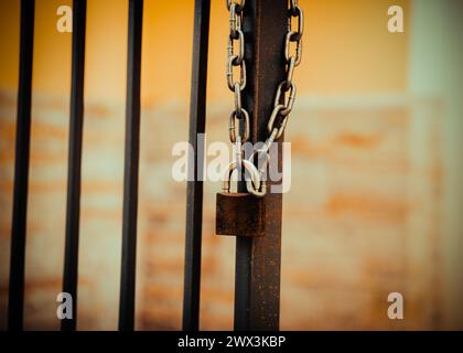 A lock is attached to a chain, which is mounted on a metal gate. This is private property. Stock Photo