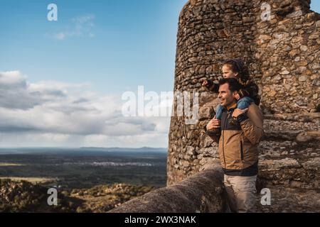 Photographer father and his fashionable son with a hat on his shoulders, happy, walking through a beautiful environment Stock Photo