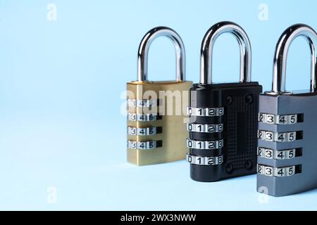 Steel combination padlocks on light blue background, closeup. Space for text Stock Photo