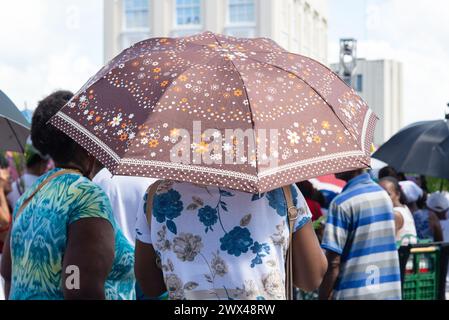 Salvador, Bahia, Brazil - April 14, 2019: People are seen protecting themselves from the sun during the Palm Sunday procession in the city of Salvador Stock Photo