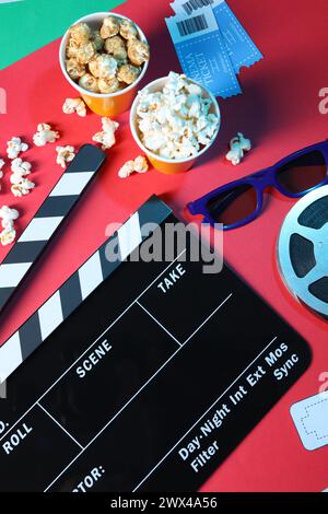 Flat lay composition with clapperboard and popcorn on color background Stock Photo