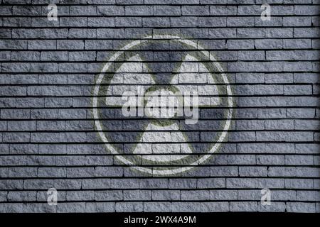 Radioactive sign on grey brick wall. Hazard symbol Stock Photo