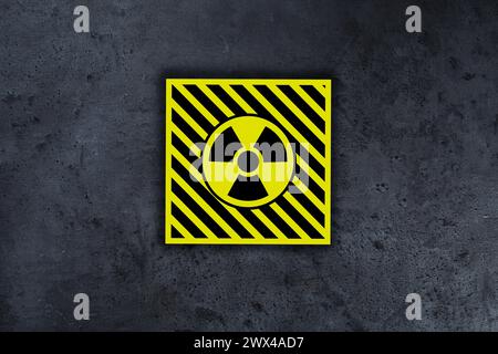Radioactive sign on grey stone wall. Hazard symbol Stock Photo
