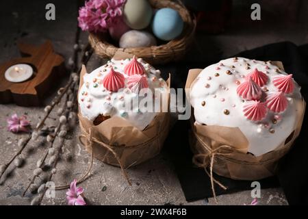 Easter cakes, painted eggs in nest and willow branches on grunge background, closeup Stock Photo