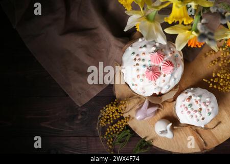 Easter cakes, rabbits, narcissus and mimosa on wooden tray Stock Photo