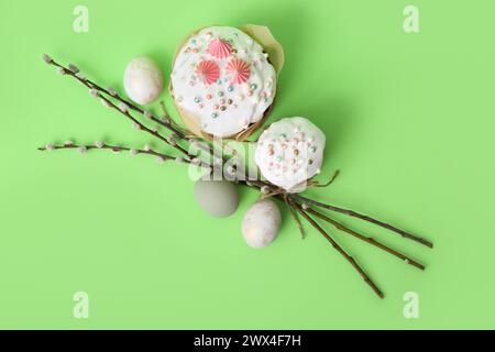 Easter cake, painted eggs and willow branches on green background Stock Photo