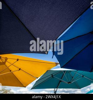 Colorful artistic umbrellas against blue sky and clouds Stock Photo