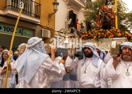 Almuneca, Spain.  Easter week in Almuneca, Spain commences with the first major event is Palm Sunday (Domingo de Ramos), the holiday held exactly one week before Easter Sunday, commemorating Jesus' famed entry into Jerusalem on a donkey. The brotherhoods organise the processions that parade through the streets and squares every day carrying beautiful 'pasos' and 'tronos' adorned with flowers and religious images that are carried on the shoulders of the participants.Here they are exiting the Church of the Encarnación in Almuñécar at the beginning of the parade. 24th March 2024 David Smith/Alamy Stock Photo