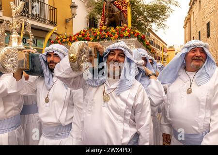 Almuneca, Spain.  Easter week in Almuneca, Spain commences with the first major event is Palm Sunday (Domingo de Ramos), the holiday held exactly one week before Easter Sunday, commemorating Jesus' famed entry into Jerusalem on a donkey. The brotherhoods organise the processions that parade through the streets and squares every day carrying beautiful 'pasos' and 'tronos' adorned with flowers and religious images that are carried on the shoulders of the participants.Here they are exiting the Church of the Encarnación in Almuñécar at the beginning of the parade. 24th March 2024 David Smith/Alamy Stock Photo