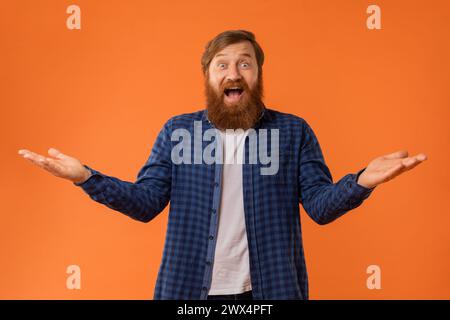 Portrait Of Joyful Bearded Redhaired Guy Spreading Hands In Excitement Stock Photo