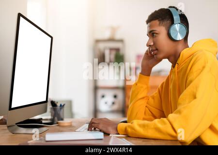 Man in yellow hoodie working at computer Stock Photo