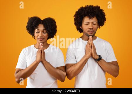Concentrated millennial african american man and woman praying Stock Photo