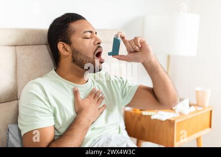 Man using inhaler during asthma attack Stock Photo
