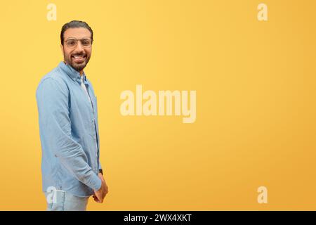 Man in denim smiling and standing confidently Stock Photo