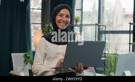 Islam businesswoman in hijab Arabian Indian muslim islamic woman business entrepreneur manager girl with laptop commerce working studying online Stock Photo
