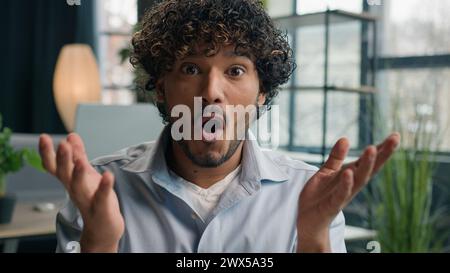 Surprised face happy Indian Arabian man ethnic guy businessman looking at camera wonder surprise amazed reaction delight good news win offer Stock Photo