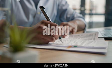 Close up unrecognizable man businessman writing paperwork report on desktop male hands signing business documents on office table student write Stock Photo
