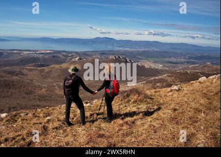 Rear view of mature couple hiking in the mountains and looking at the view Stock Photo