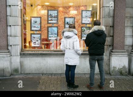 File photo dated 04/12/14 of members of the public looking in the window of an estate agents in South Kensington, London. House sellers are typically shaving £10,000 off their original asking price to achieve a sale, according to a property website. Across the UK, the average discount of 3.9% recorded in March is a 'marked improvement' compared with an average discount of £14,250 or 4.5% recorded in November 2023, Zoopla said. Issue date: Thursday March 28, 2024. Stock Photo