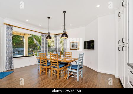 Wooden dining set by window in room Stock Photo