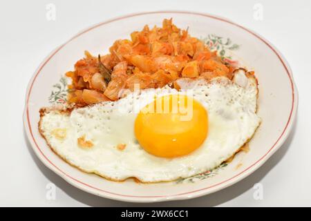 On the plate is breakfast consisting of stewed cabbage and scrambled eggs. Stock Photo