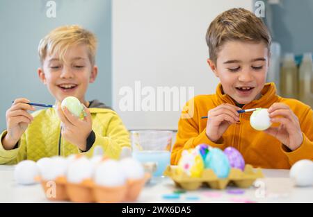 Children having fun painting eggs for Easter Stock Photo