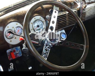 The interior of a 1951 Chevrolet showing the steering wheel and dashboard controls. Stock Photo