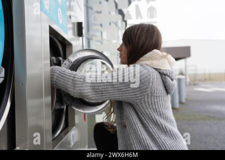 Woman doing laundry in an express laundry Stock Photo