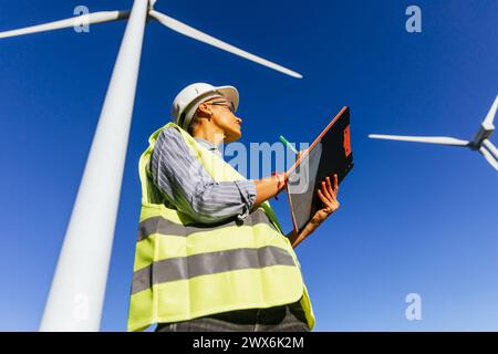 Female engineer working on windmill farm report. Stock Photo