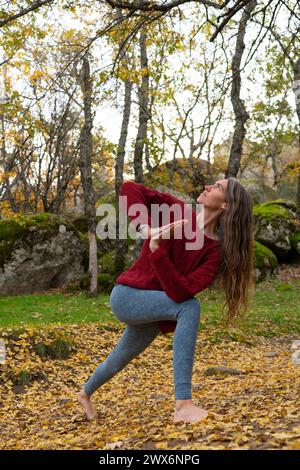 Middle aged woman practicing yoga in nature Stock Photo