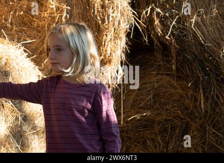 Portrait of a child with hay in the background on a farm Stock Photo