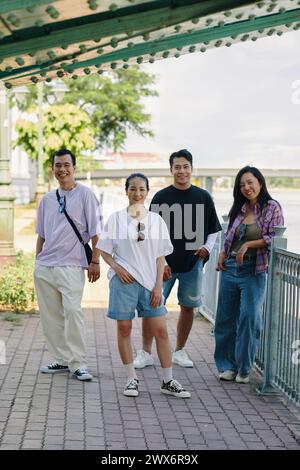 Group of friends spending time walking along river embankment Stock Photo