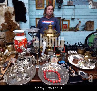 Flea market. Man hoarder standing at the counter selling old things and souvenirs. September 26, 2019. Kyiv, Ukraine Stock Photo