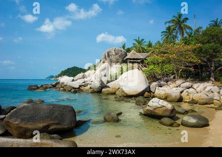 Tropical island paradise, Small bay among rocks with turquoise clear sea water, hurt behind big boulders. Romantic hidden vacation place. Koh Tao isla Stock Photo